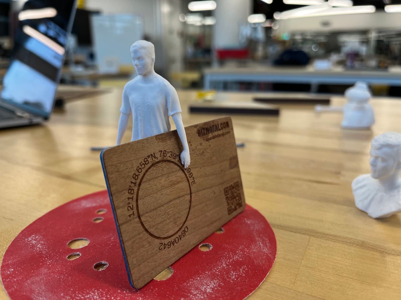 3D printed figure holding the laser etched business card