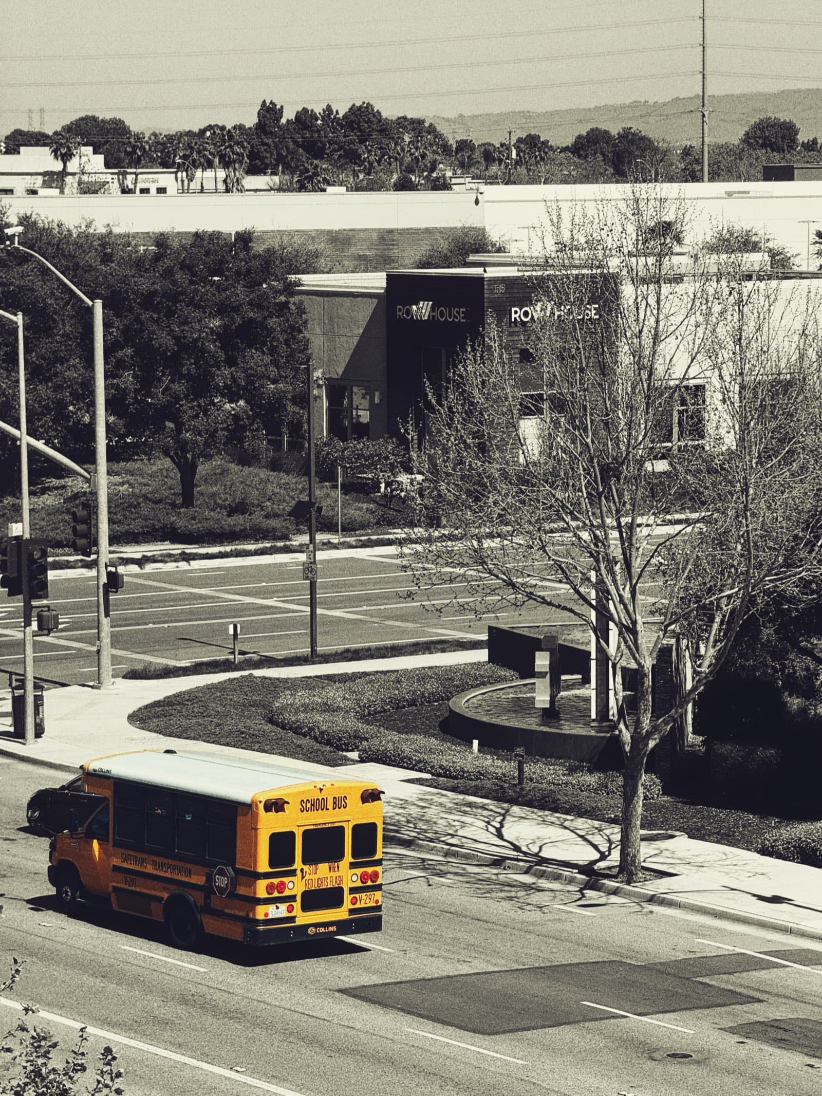 Yellow school bus on a desaturated city street