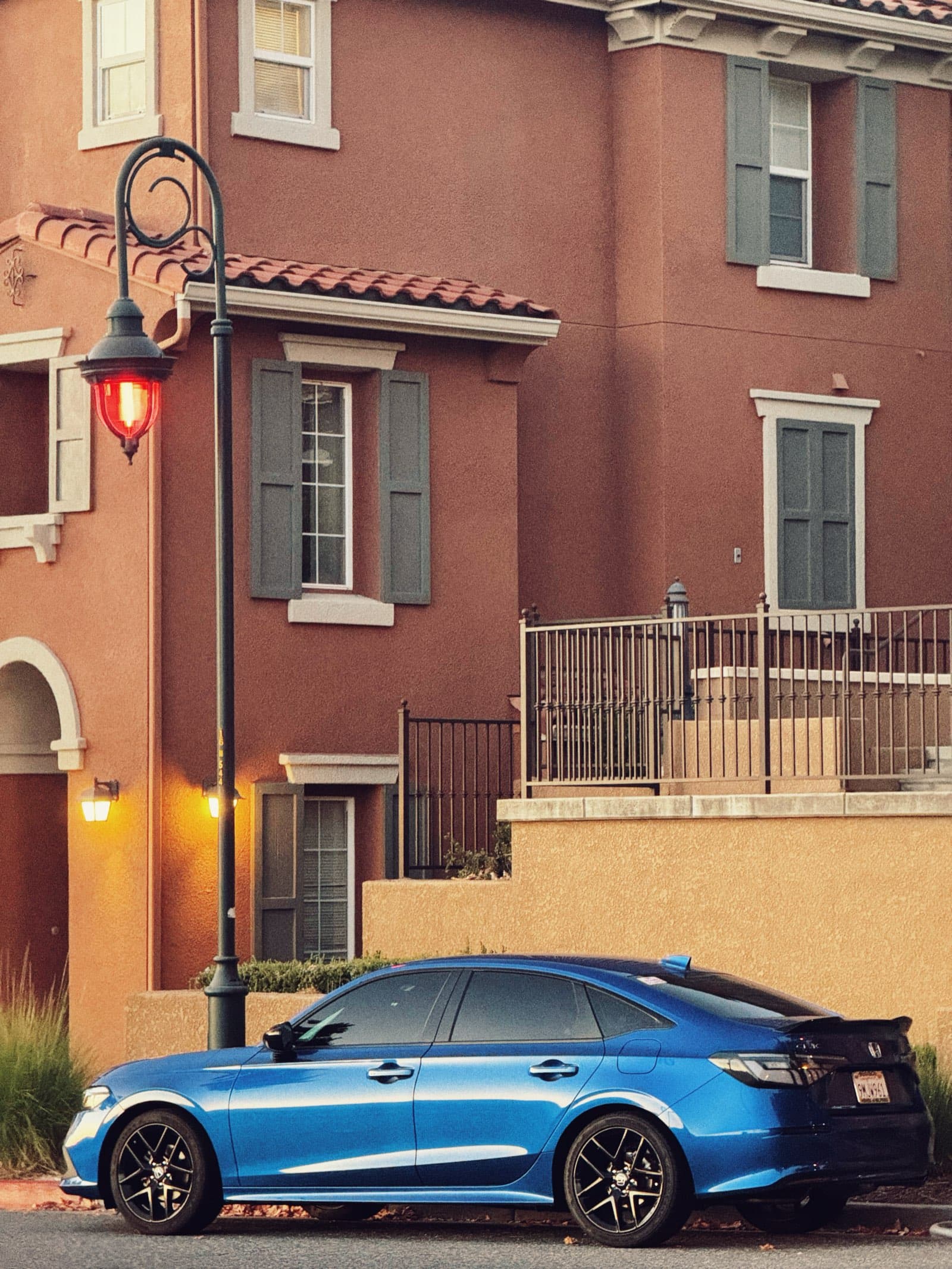 Blue Civic under a warm streetlamp glow at golden hour