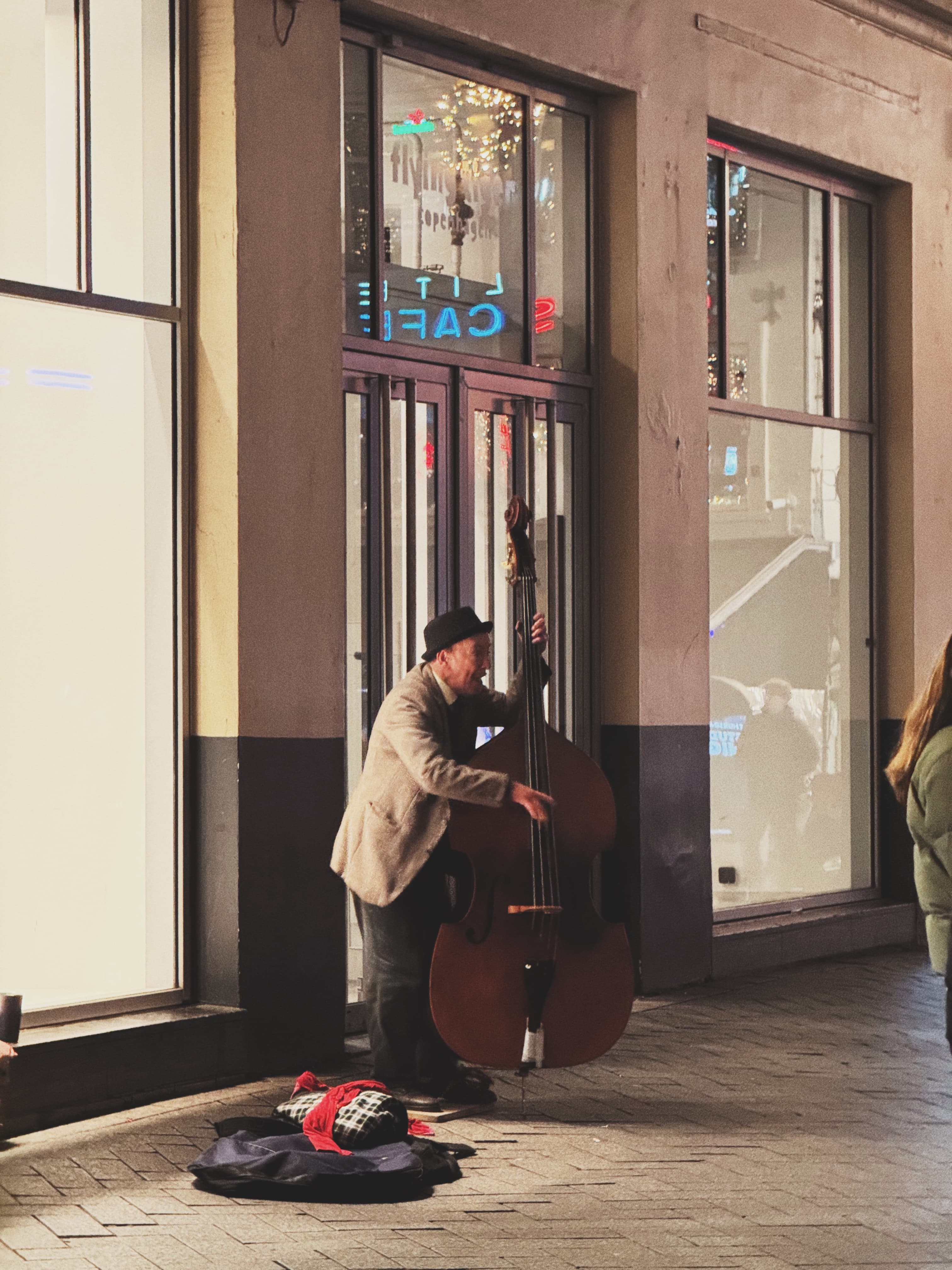 Street musician playing a double bass outside an Amsterdam cafe